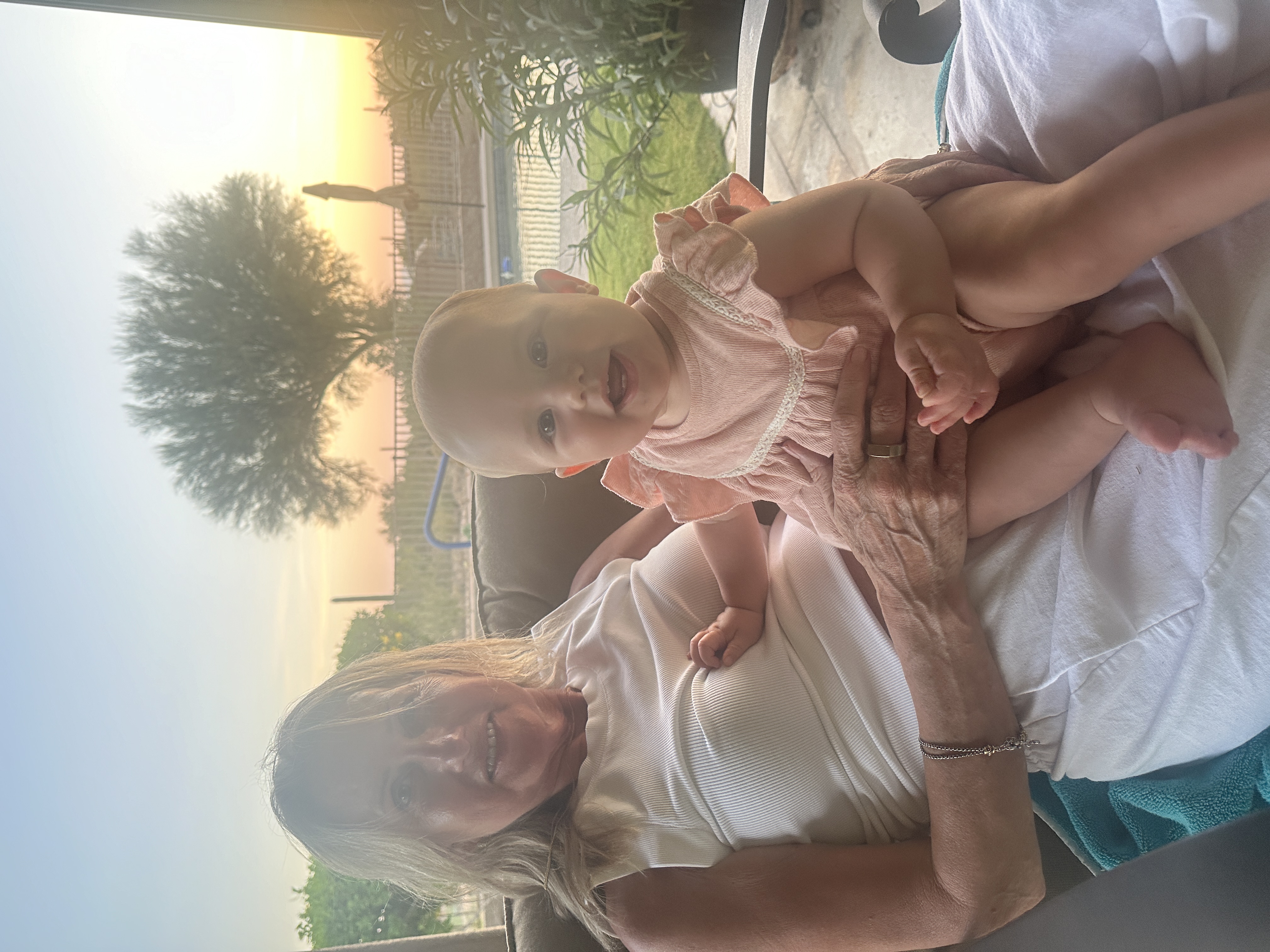 Leslie Summers holding her granddaughter Summer at sunset